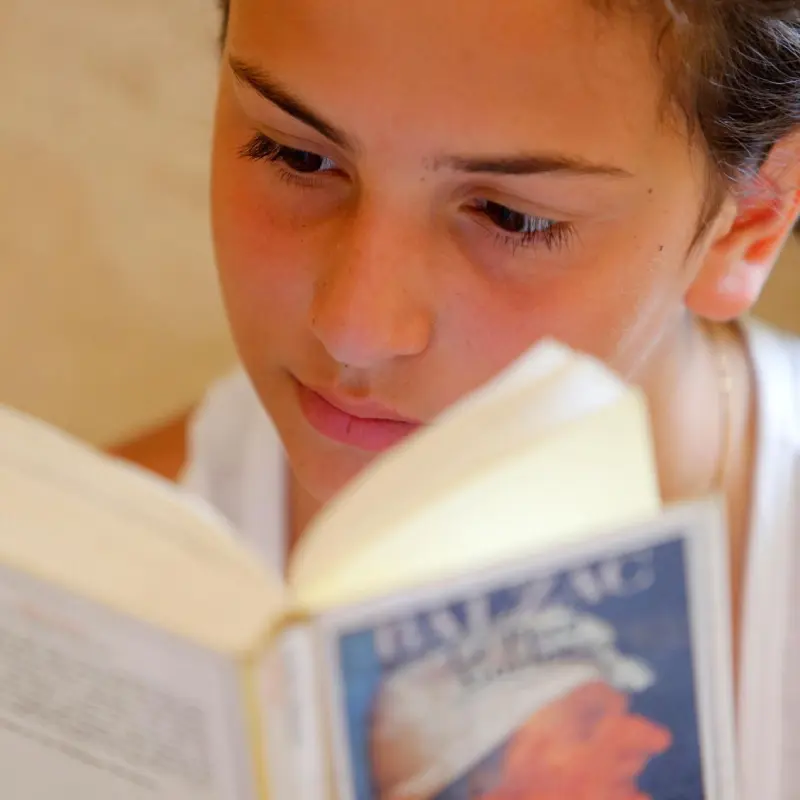 child reading book with focused attention on story